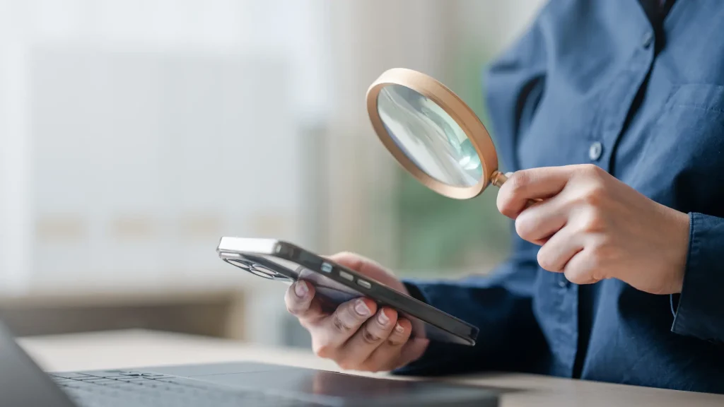 Keyword research guide - person using a magnifying guide to look at cellphone